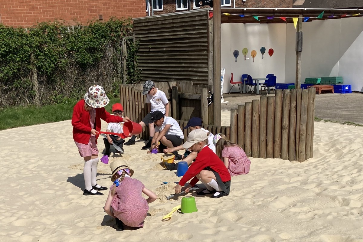 Children enjoying digging and building sandcastles in the new sandpit