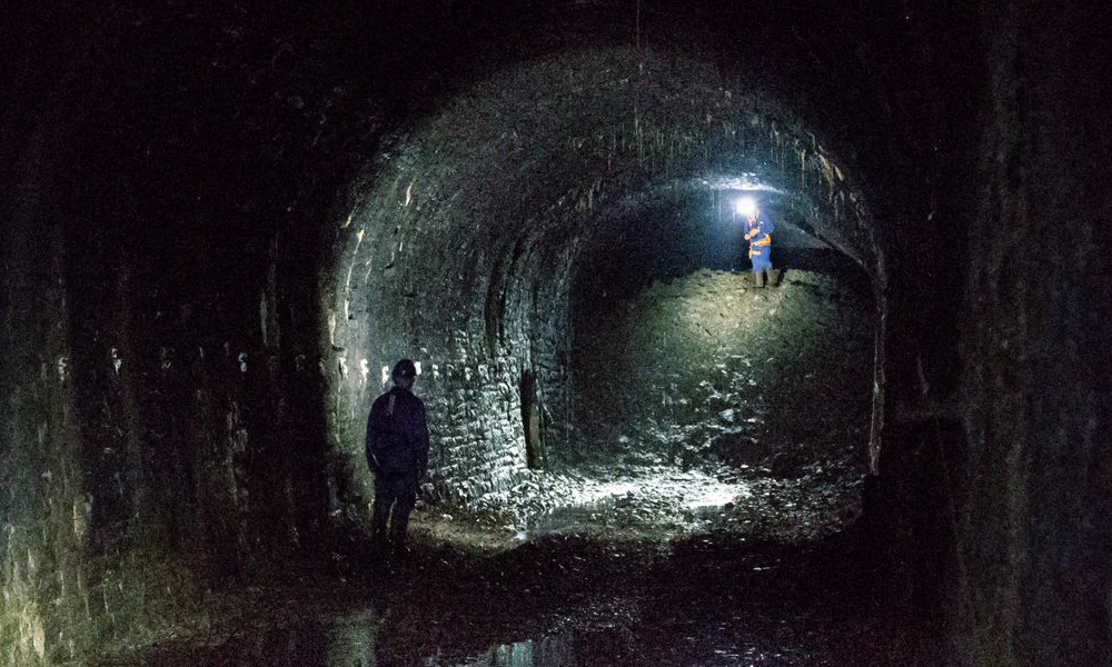 Volunteers inspect a blocked section of the tunnel