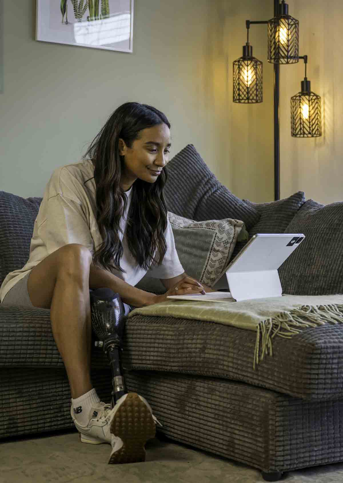 woman sitting on couch looking at her laptop