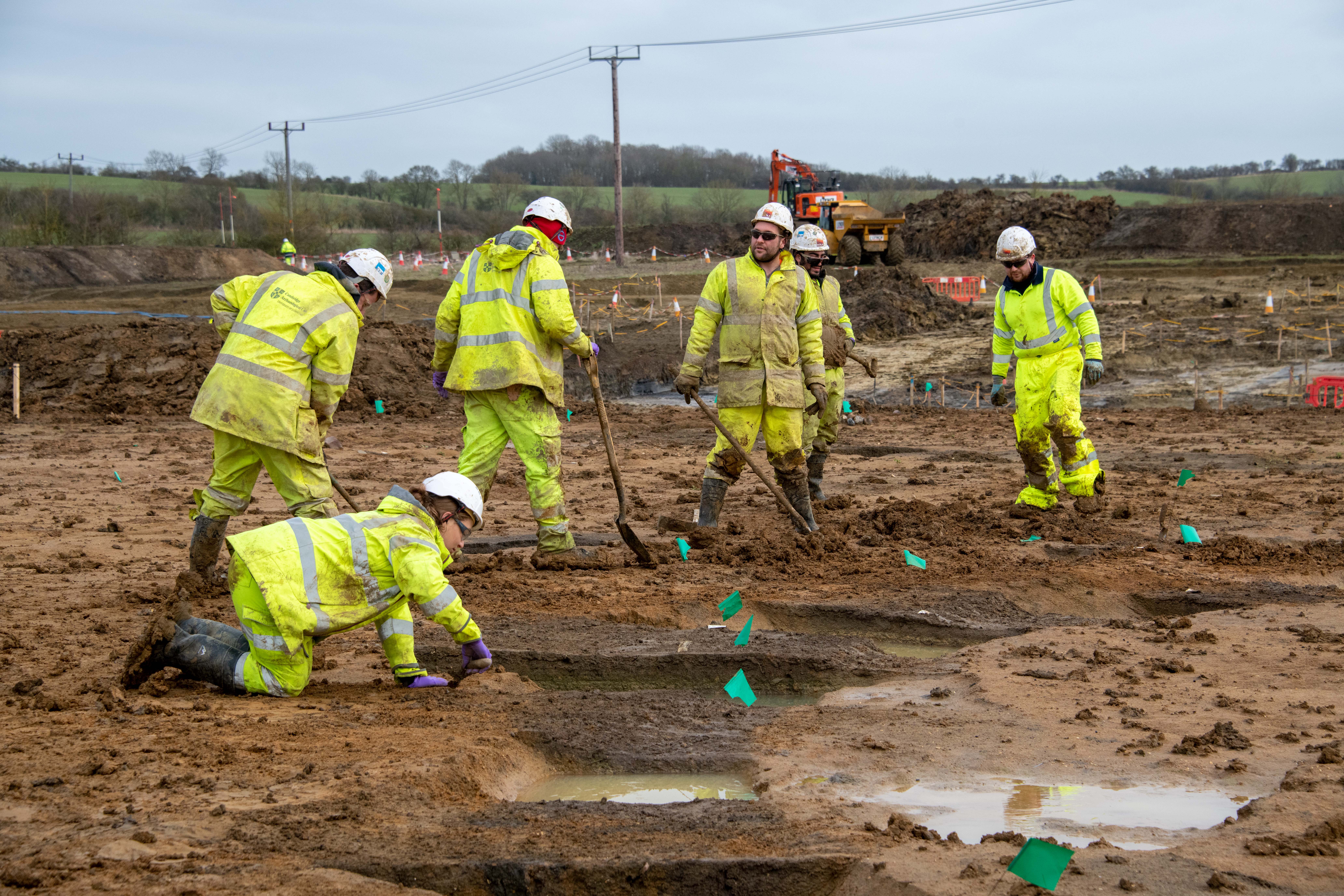 Muddy archaeologists digging on the A428