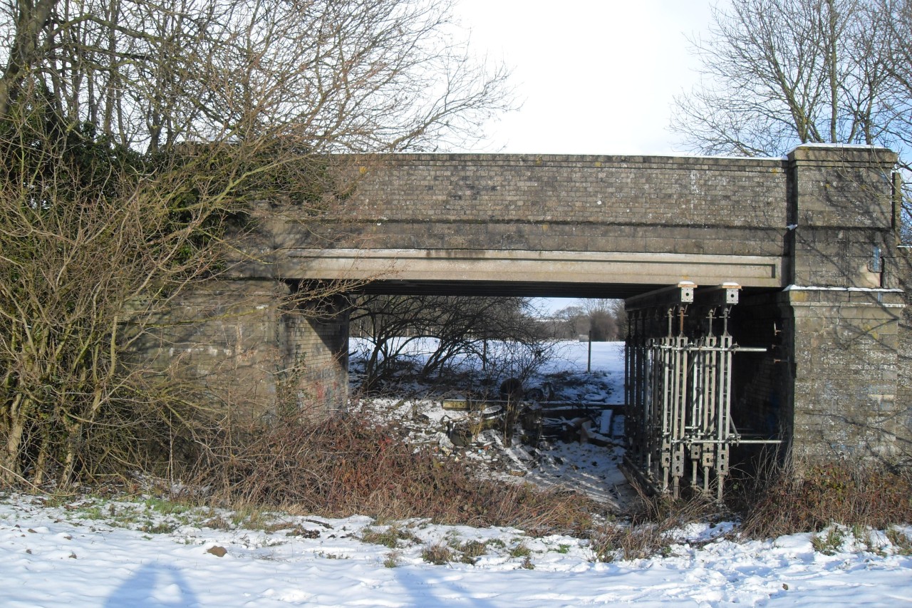 Congham bridge southern side December 2009 showing tree growing into wingwall and propping of the deck