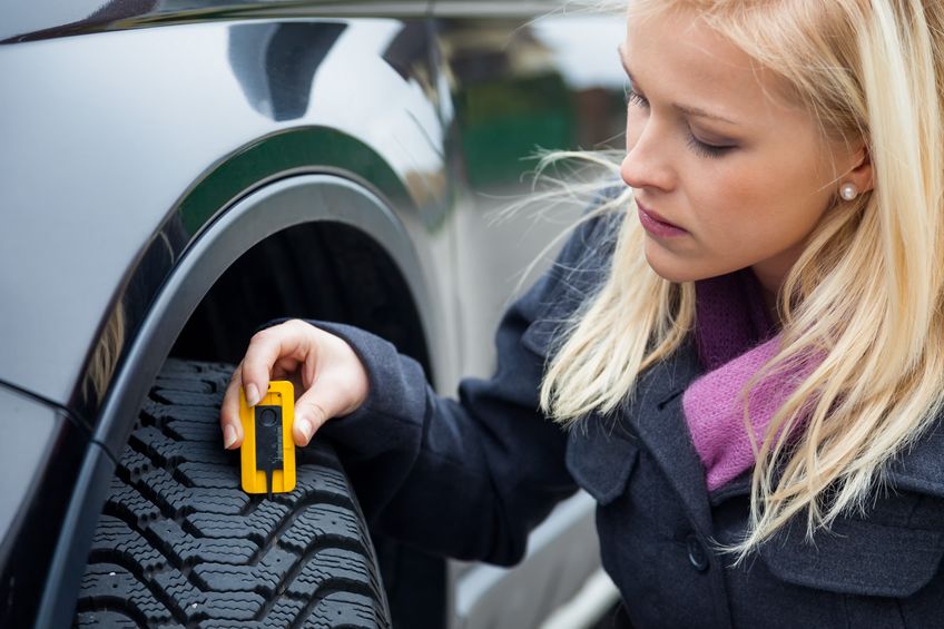Girl checking tyre tread