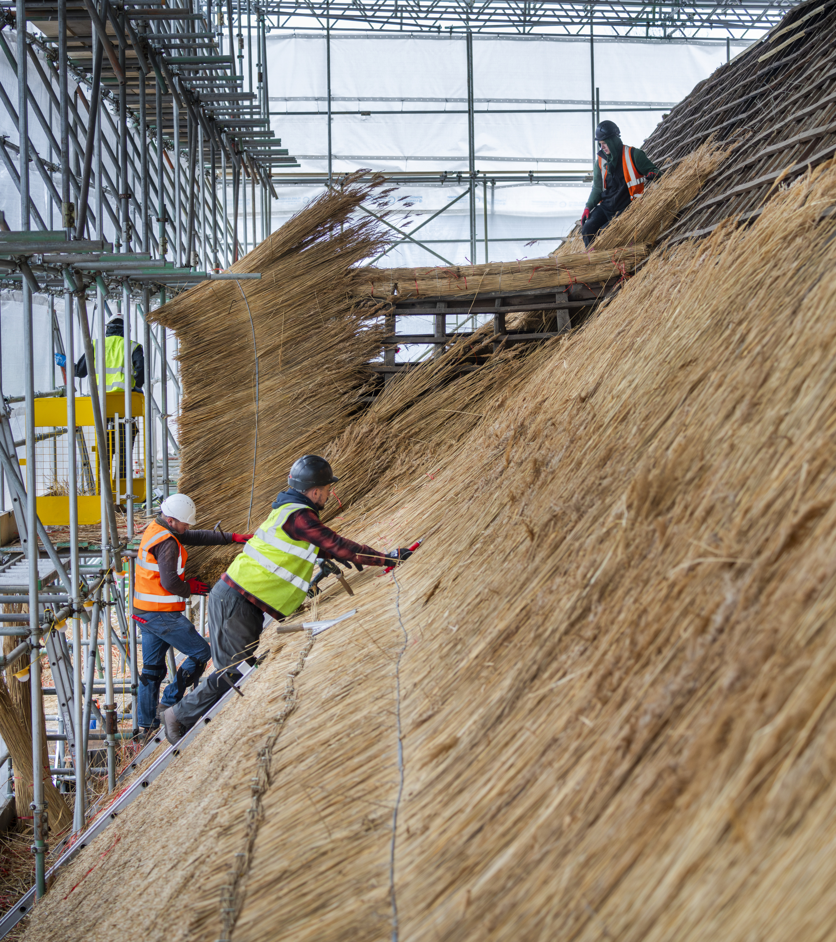 Stepping up to re-thatch the Tithe Barn. Copyright Historic England Archive.