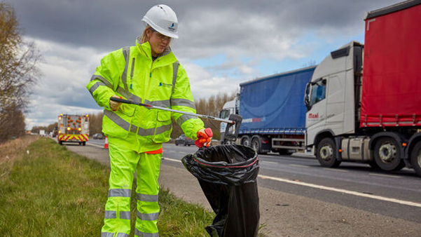 picking litter next to a busy road with fast lorrys passing by