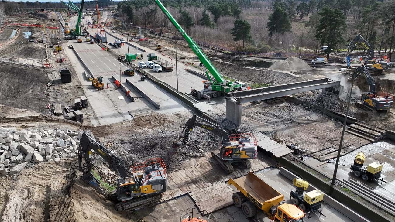 Drills break out bridge abutments while main girders are lifted out by crane