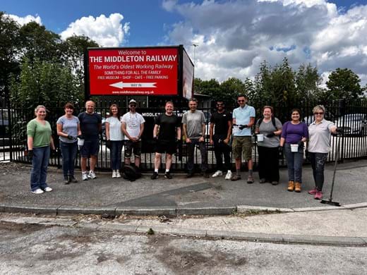 A team of volunteers stand in front of a sign for Middleton Railway in Leeds