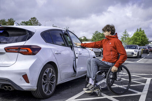 man in wheelchair preparing to get into car