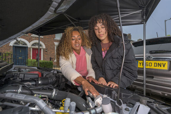 two women inspecting their car engine