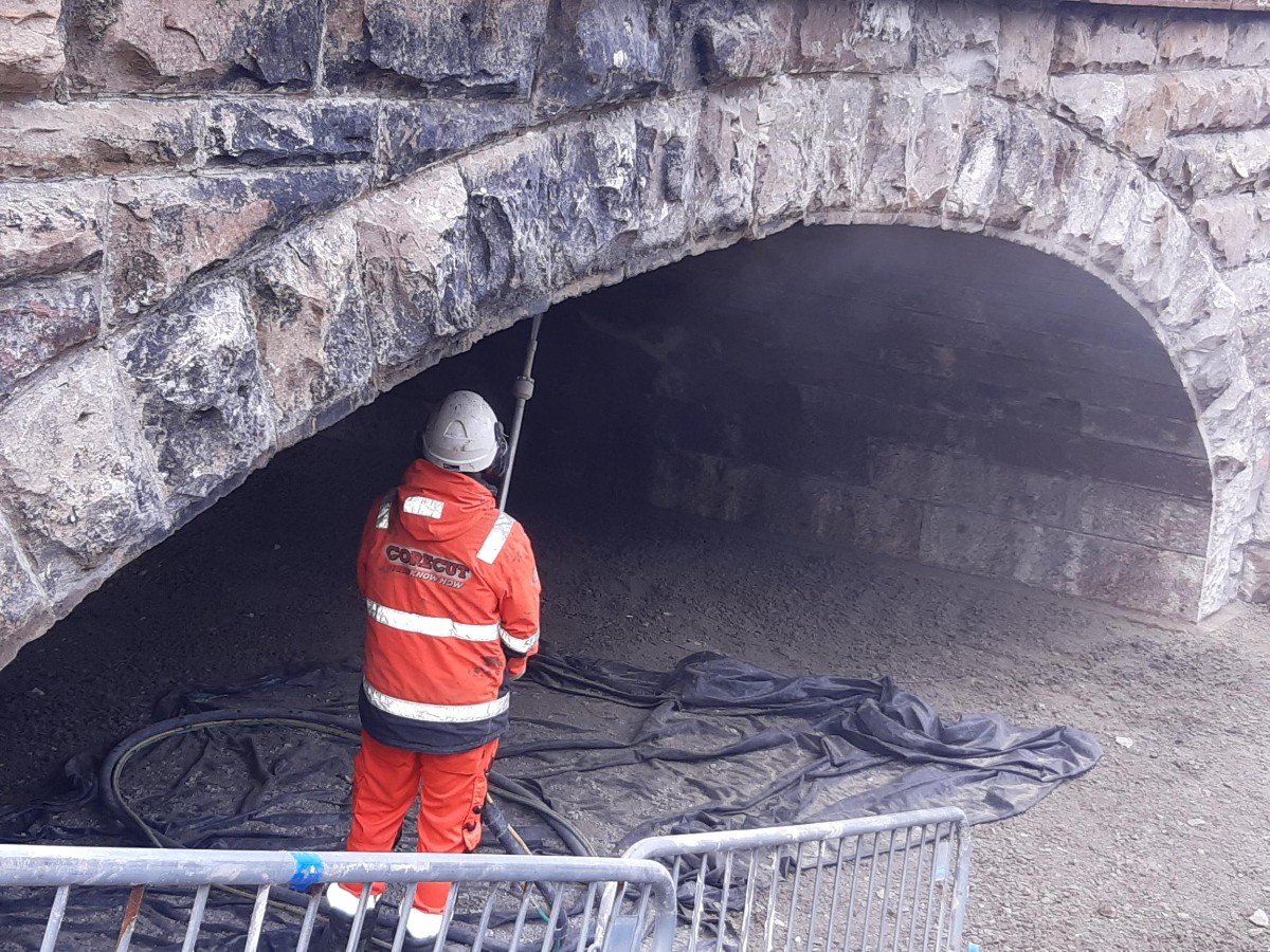 Contractor cleans arch to remove residual foamed concrete