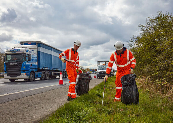 roadworkers picking litter next to busy road